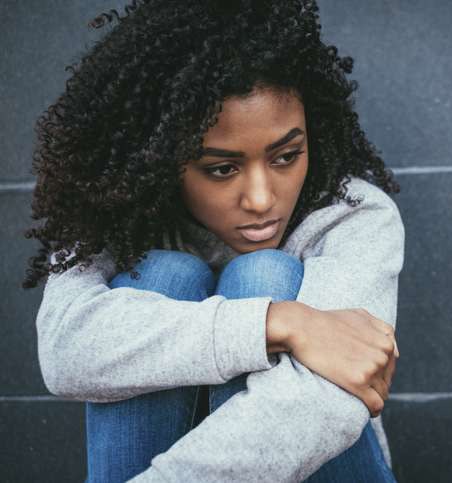 Woman with hands around knees