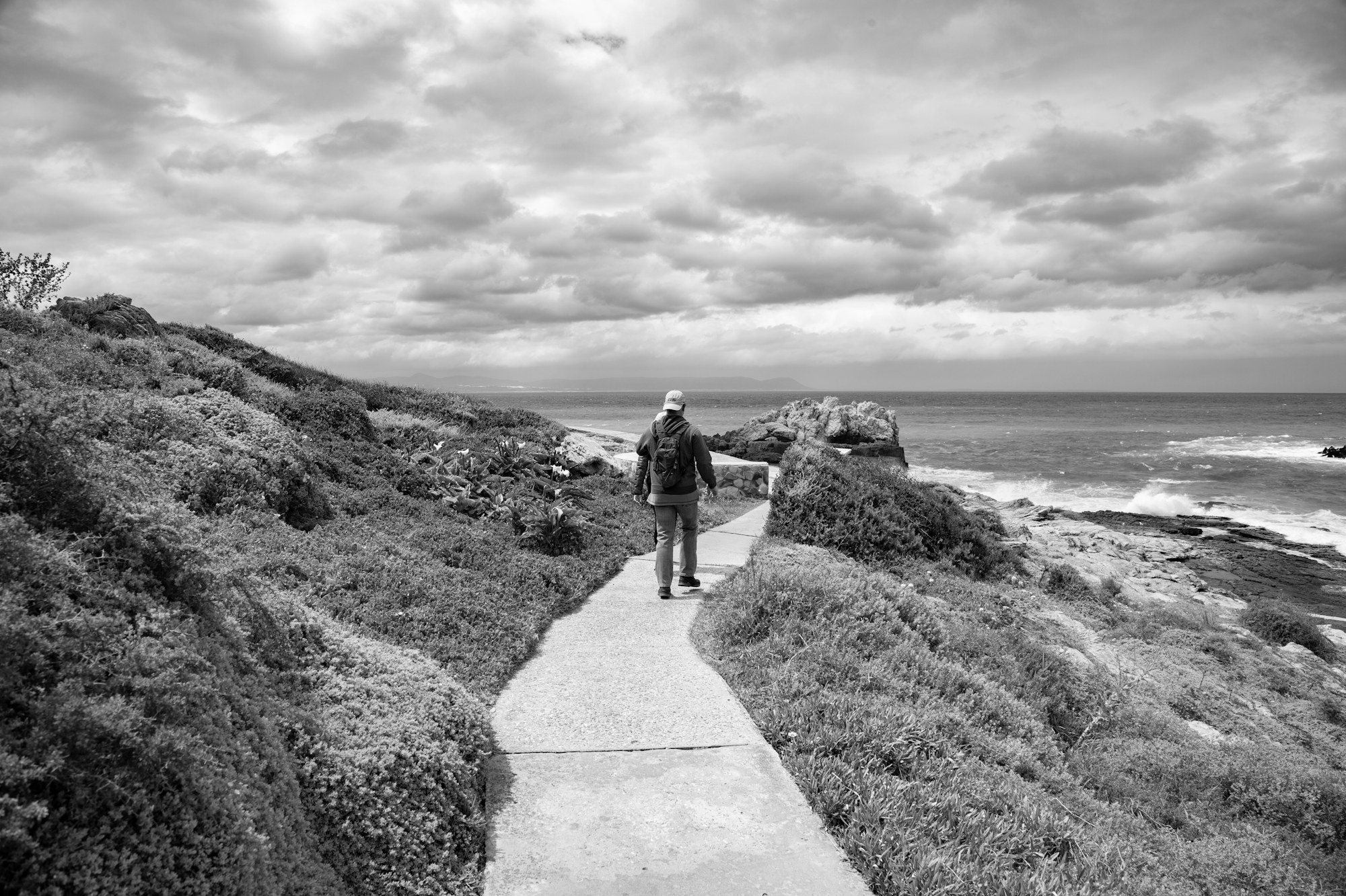 Person walking on a coastal path representing movement-based, non-opioid chronic pain management in recovery