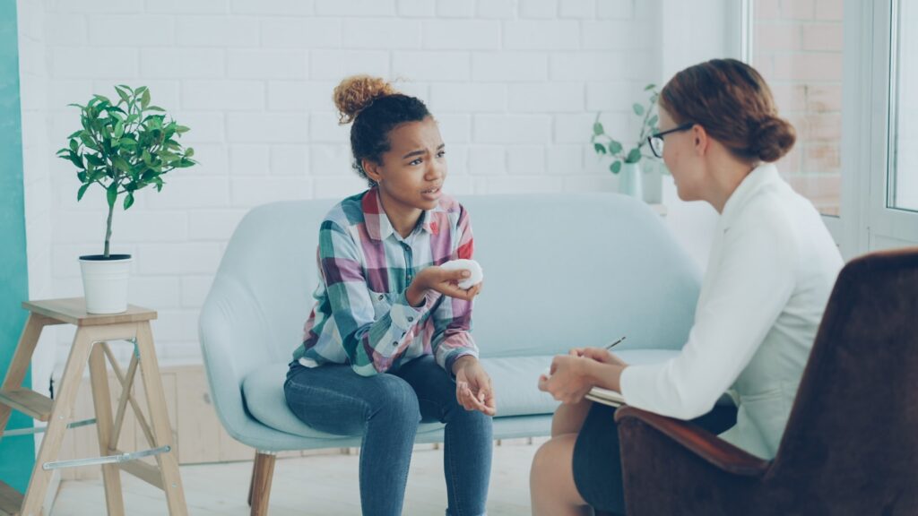 Therapist talking with a teenage client during an adolescent counseling session