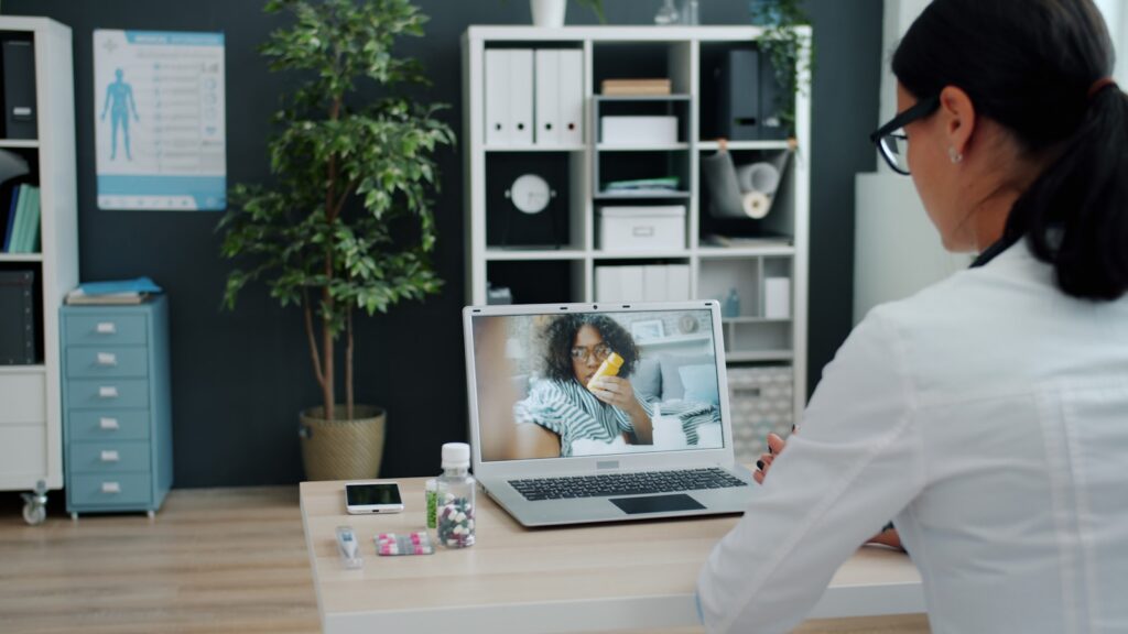 Doctor conducting a telehealth video consultation with a patient on a laptop