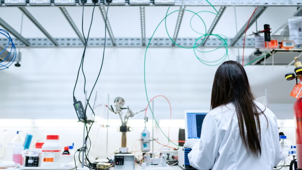 Scientist in a white lab coat working with equipment in a research laboratory