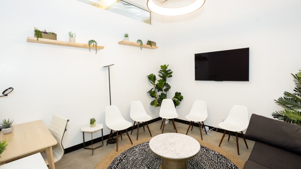 Modern treatment center waiting room with white chairs and natural light