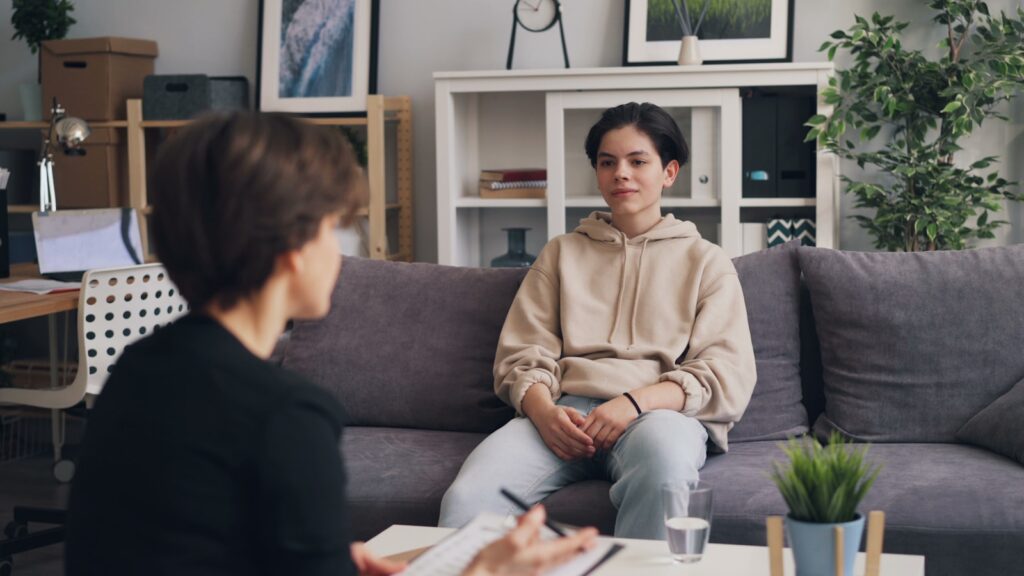 Counselor talking with a client on a couch while choosing a treatment program